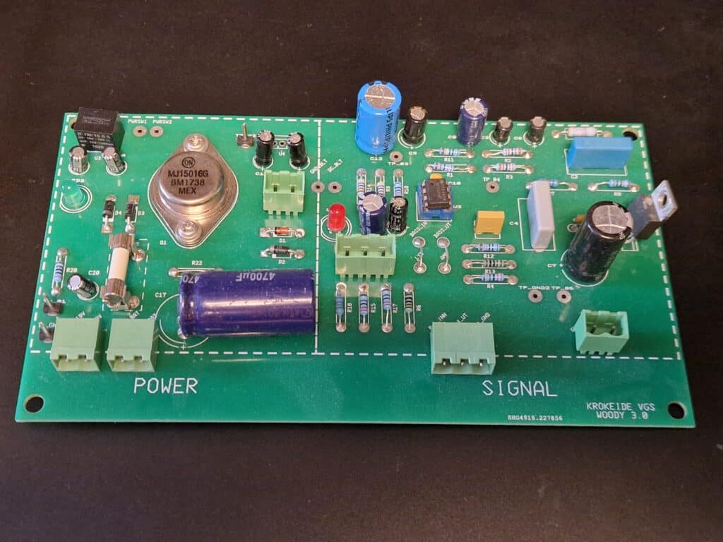 04 - Første elev kretskort Et grønt kretskort med ulike elektroniske komponenter, blant annet transistorer, kondensatorer, motstander og kontakter. Det er merket med «POWER» og «SIGNAL».